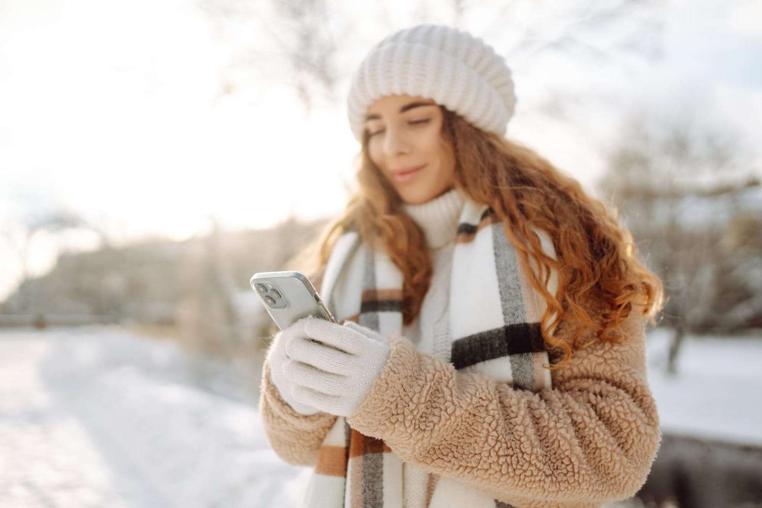 Young woman using the Emma app on a smartphone to track spending and set a budget.