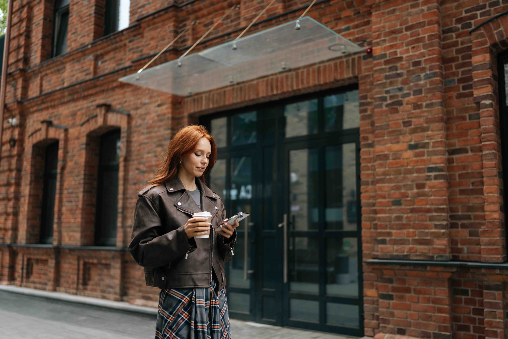 young-woman-enjoying-leisurely-walk-through-city-holding-coffee-cup-using_the_emma_app